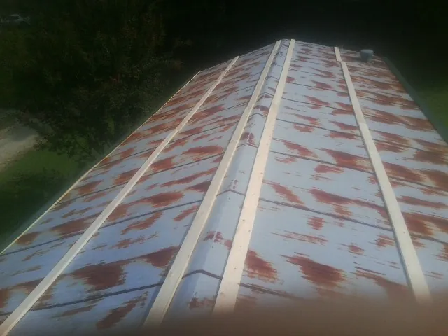 Rusted metal roof panels with new wood purlins before replacement — Storm Damage Roof Repair in Grand River by Roofing Brothers